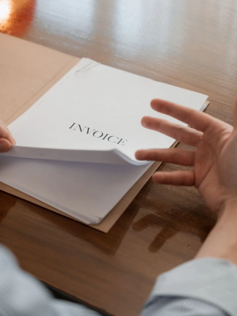 A printed NET 30 invoice with itemized fleet parts on a procurement manager's desk.